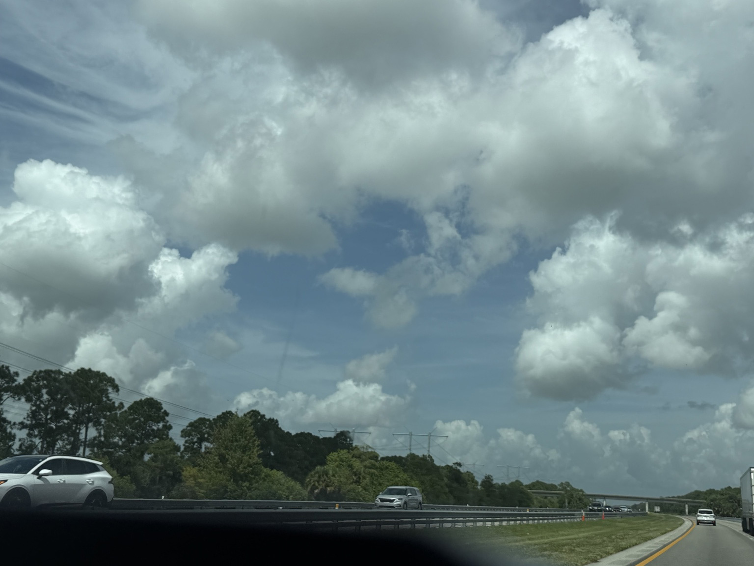 Original fourth photograph, clouds above a road and passing cars.